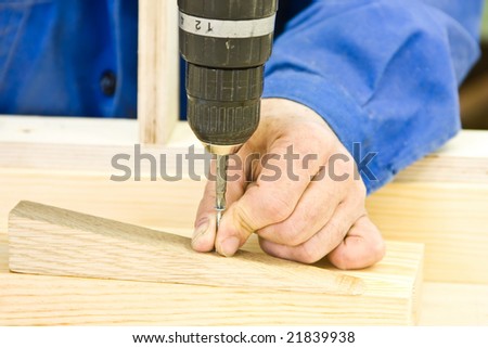 Hands working wrap Screwdriver System Accessories screw in a wooden piece