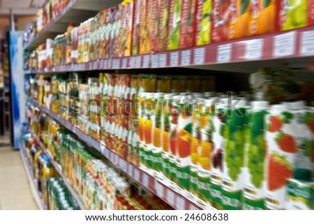 Shelves with fruit juices in boxes in a supermarket in soft focus