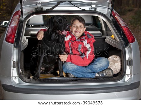 The boy with a dog in a car luggage carrier