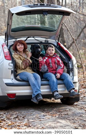 Mum with the son and a dog in the car