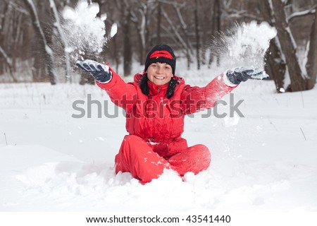 The young woman throws snow hands. On face a shade from snow lumps.