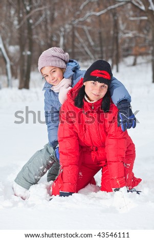 Mother with her daughter outside in snow