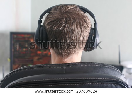 Young man playing computer game back of the head view