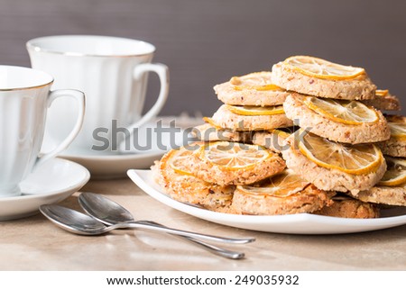 two cups of tea with almond biscuits with lemon