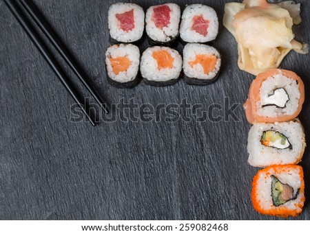 sushi and rolls on black background top view