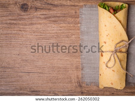 fresh tortilla wraps with vegetables on wooden background top view