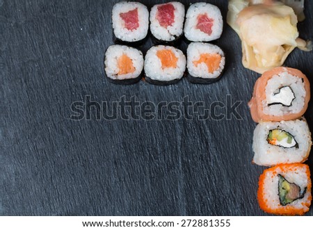 sushi and rolls on black background top view