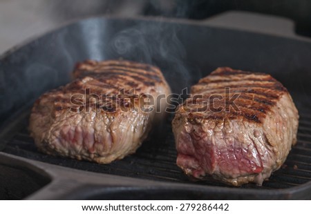 Hot Grilled beef steaks are cooking on grill pan