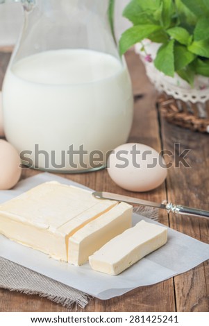 Butter on sheet of paper on wooden background