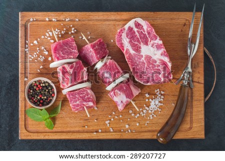 Raw pork meat cut into cubes ready for bbq (kebab) on black background