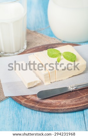 Butter on sheet of paper on blue wooden background