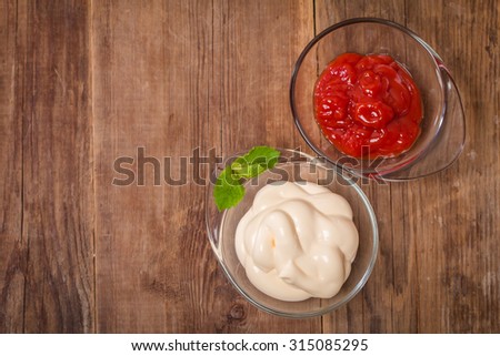 ketchup and mayonnaise - two kinds of sauces on wooden background top view