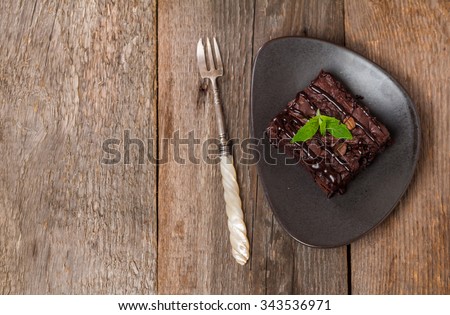 Cake chocolate brownies with dark chocolate  dressing and mint on wooden table, top view