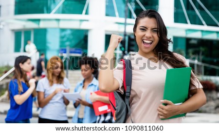 Latin american female student celebrating successful exam outdoor on campus of university
