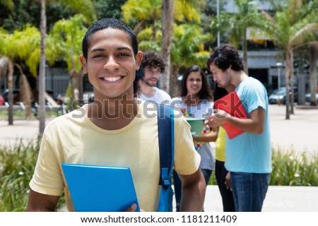 Happy egyptian scholarship student with group of international students outdoor on campus of university