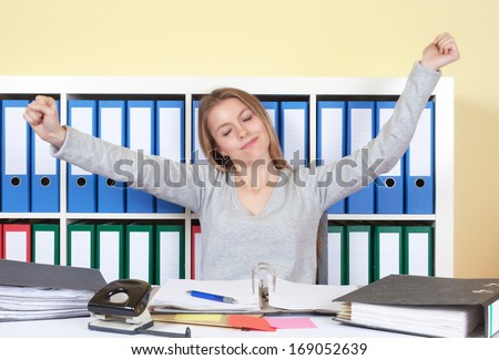 Young woman stretching at office