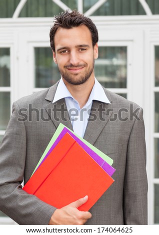 Smiling latin businessman with paperwork