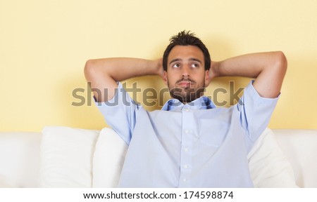 Thoughtful latin man on a sofa