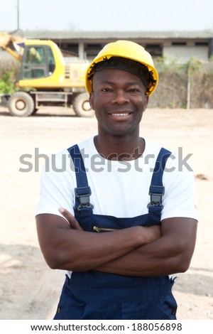Standing african worker with crossed arms at construction site