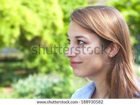 Smiling woman in a park looking to the left