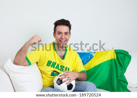 Goal celebrations of a brazilian soccer fan at sofa