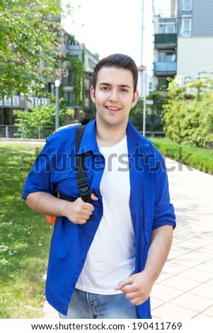 Male student on campus walking at camera