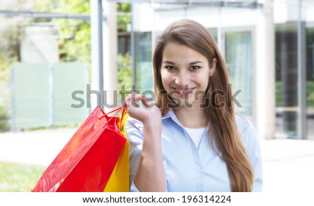 Young woman with shopping bags looking at camera