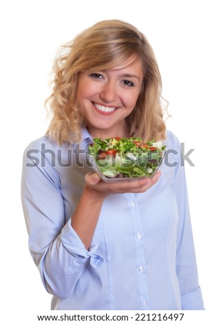 Laughing blond woman eating fresh salad