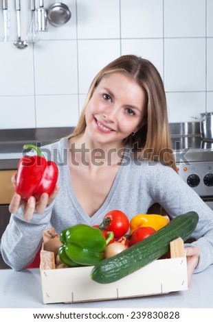 Attractive woman in the kitchen loves fresh vegetables