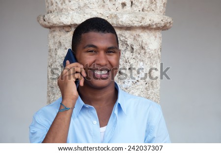 Attractive latin guy with phone in a colonial town