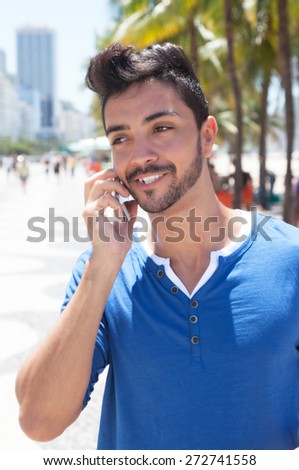 Brazilian guy with mobile phone at Aveniada Atlantica at Rio de Janeiro