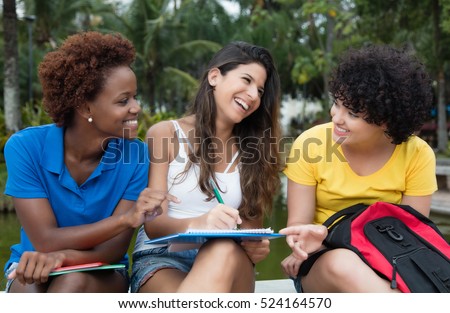 Group of learning multicultural female student outdoor in a park in the summer