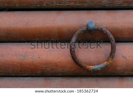 Rusty metal ring with the wooden wall