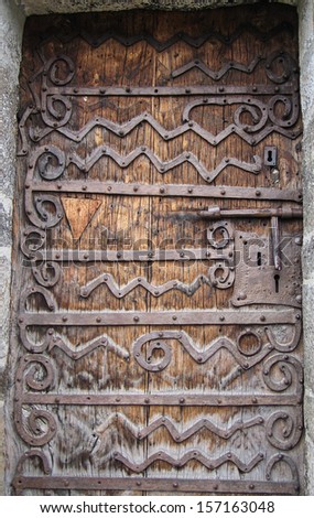Solid looking church door with ornate hinges.