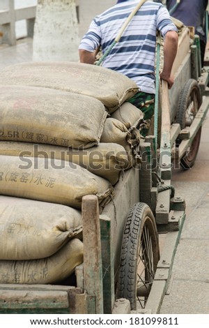 XIAMEN - MARCH 4:  workers transport goods at Gulangyu Island on March 4, 2014 in Xiamen, China. Although Xiamen is China\'s no.8 biggest harbor there is still a lot of physical labor activity.