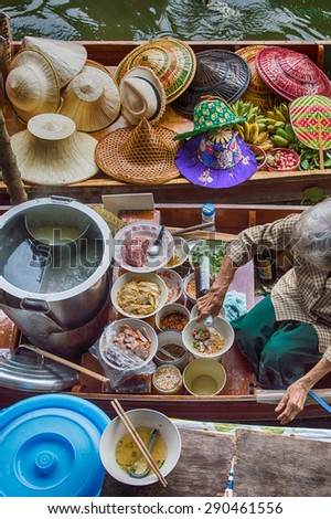 Food vendor at the Damnoen Saduak Floating Market preparing Thai style food, Thailand.