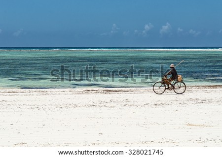 Local Riding Bike Down Beach, Zanzibar, Tanzania