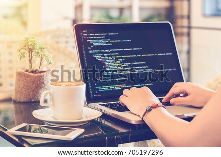 A programmer typing source codes in a coffee shop with a relaxing working environment. Studying, Working, Technology, Freelance Work, Web Design Business, and Web Development Concept.