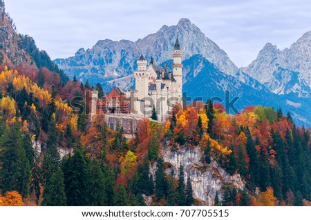 Beautiful autumn scenery of Neuschwanstein Castle with colorful autumn trees and the Alps on background. Bavaria, Germany.