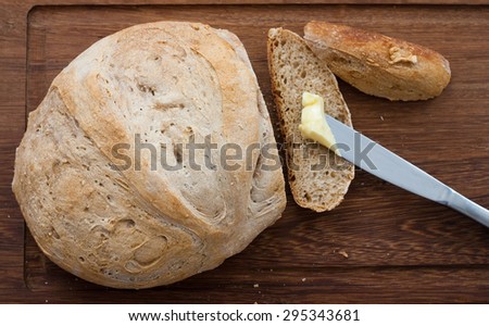 knife, home made bread and butter on wooden board - studio shot