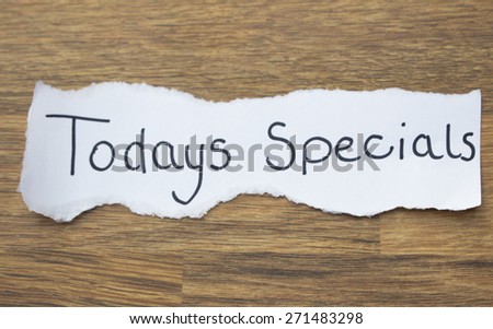 Todays specials written on torn paper, placed on wooden background