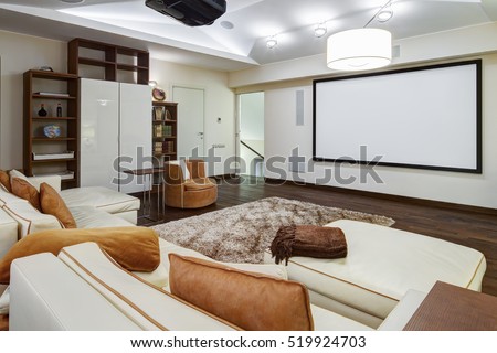 Theater room in luxury home with white big leather sofa and chairs