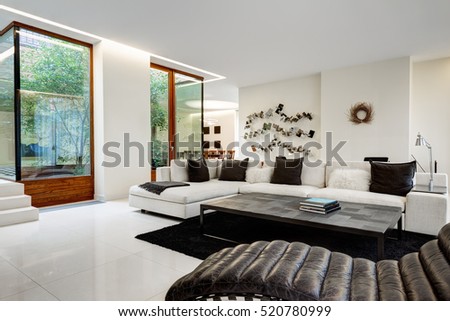 Large and comfortable living room with a white sofa in a luxurious mansion with a winter garden