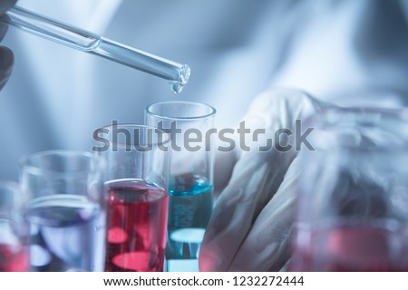 Researcher with glass laboratory chemical test tubes with liquid for analytical , medical, pharmaceutical and scientific research concept.