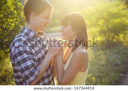 happy young couple on the walk outdoors in summer