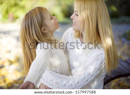 mother and daughter having fun in the autumn park. mother and daughter outdoors.