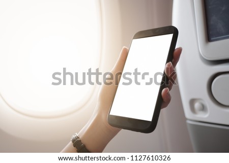 touching and slide mobile phone screen on airplane or aircraft,blank mobile phone screen mock up,selective focus