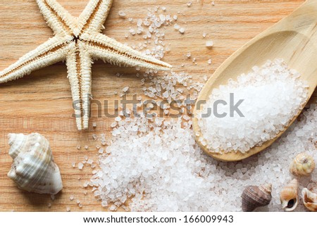 Sea Salt Crystals In Wooden Spoon With Sea Shells And Starfish On Wooden Background