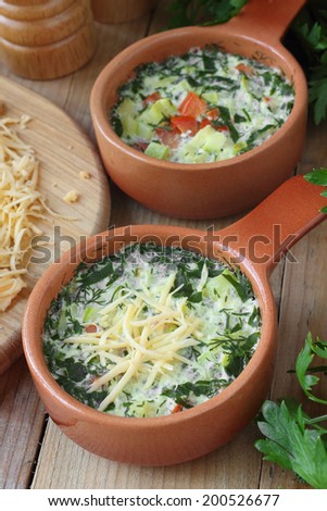 Omelette with vegetables and herbs cooked by steaming in ceramic pots