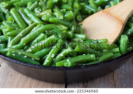 Cooked green beans with sesame seeds in frying pan